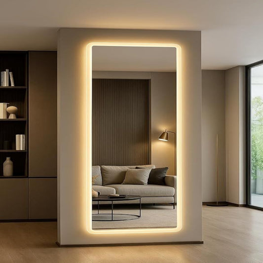 Modern interior with a large illuminated floor mirror reflecting a living room.