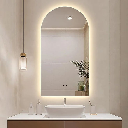 Modern bathroom vanity with illuminated mirror and decorative elements.