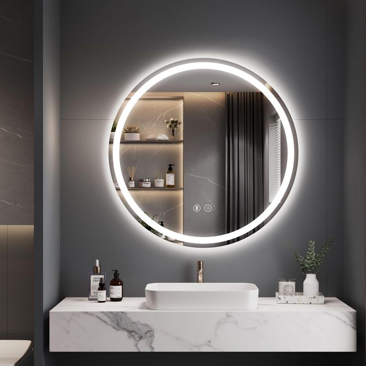 Bathroom vanity with a round illuminated mirror on a gray wall.