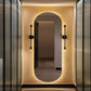 Modern interior with an oval mirror and wall lights in a hallway.