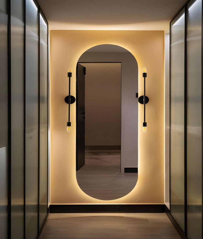 Modern interior with an oval mirror and wall lights in a hallway.
