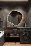 Modern bathroom with dark wooden vanity, round mirror, and washing machine.
