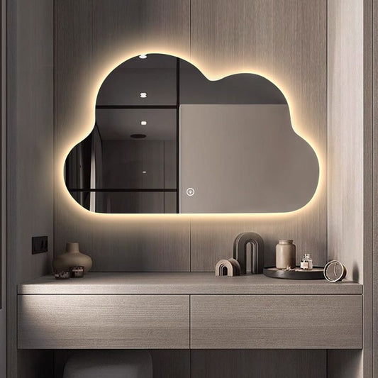Modern bathroom vanity with a cloud-shaped mirror and decorative items.