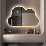 Modern bathroom vanity with a cloud-shaped mirror and decorative items.