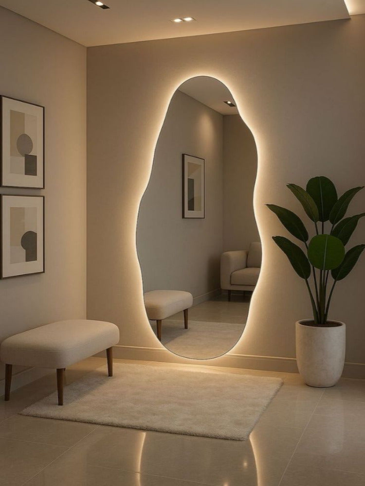 Modern interior with a large oval mirror, bench, and plant in a well-lit room.