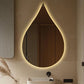 Modern bathroom with a teardrop-shaped mirror emitting a warm glow.