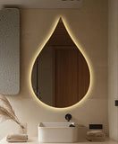 Modern bathroom with a teardrop-shaped mirror emitting a warm glow.