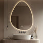 Modern bathroom with a round illuminated mirror, sink, and decorative elements.