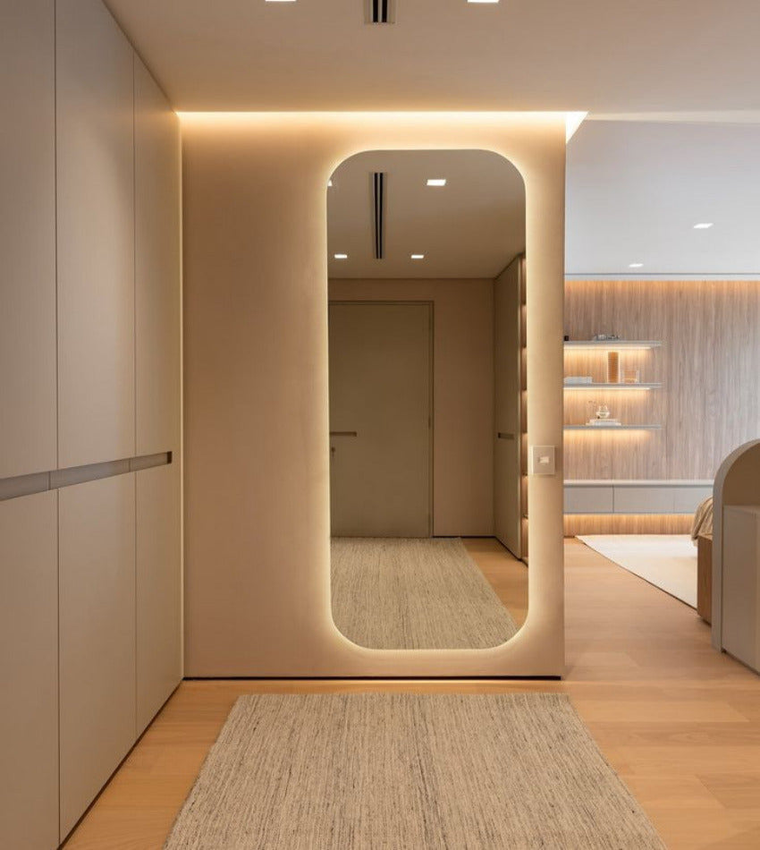 Modern interior with a large mirror reflecting a well-lit room.