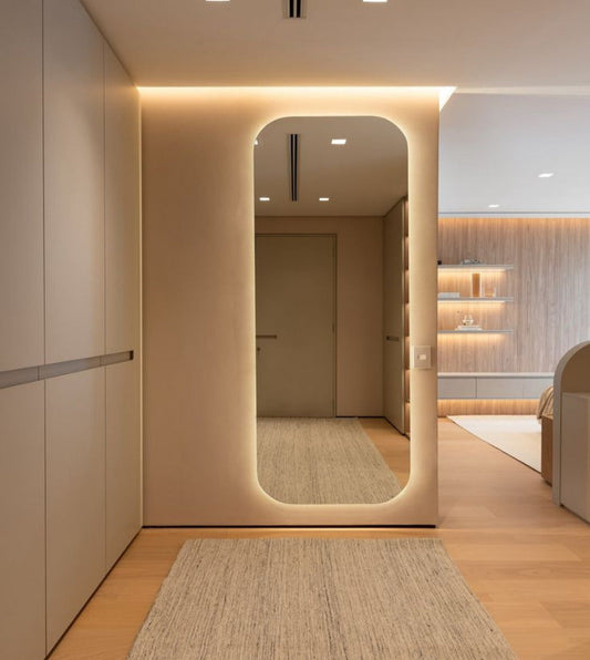 Modern interior with a large mirror reflecting a well-lit room.