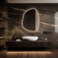 Modern bathroom with a marble wall, illuminated mirror, and wooden vanity.