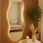 Decorative mirror with a wooden frame and LED lighting in a room with a sofa and table.