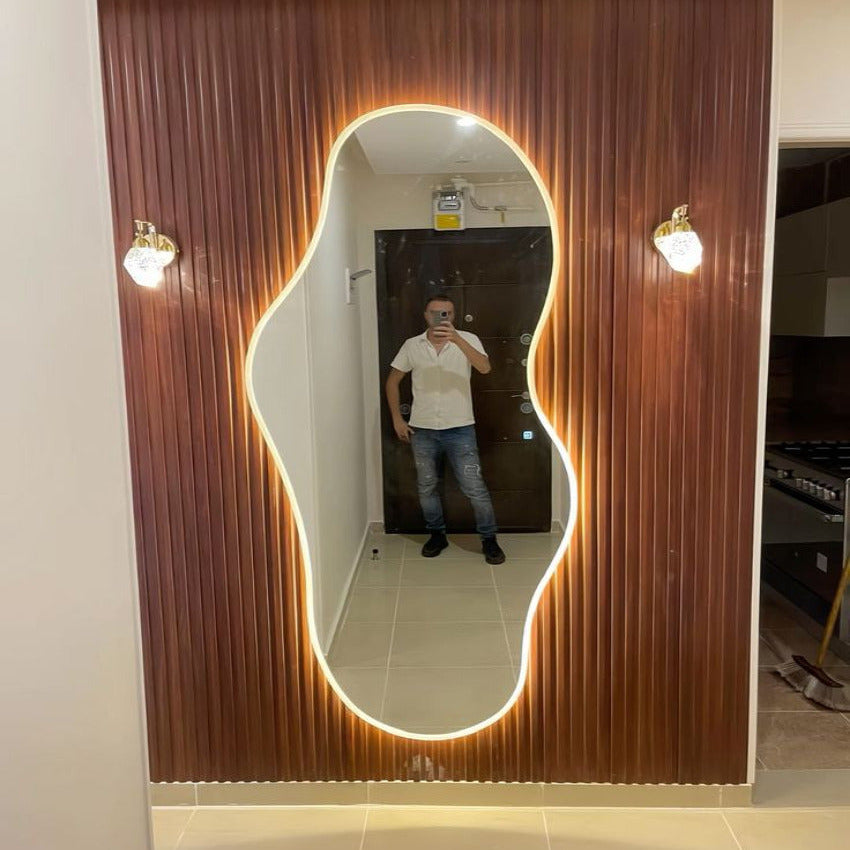Person taking a mirror selfie in a modern bathroom with a decorative mirror.