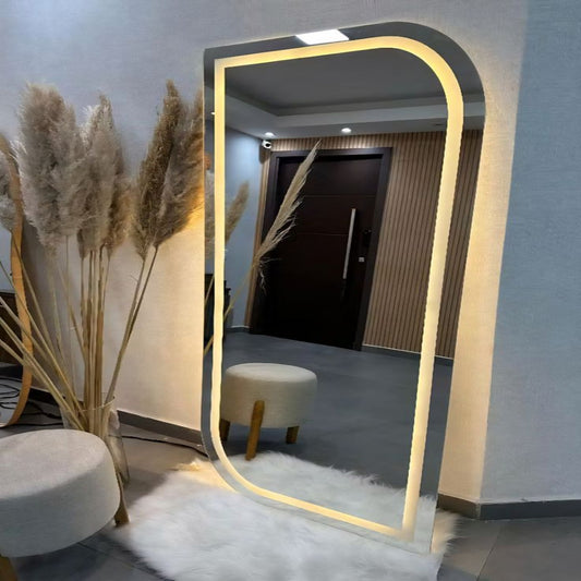 Floor mirror with LED lighting in a room setting with decor elements.