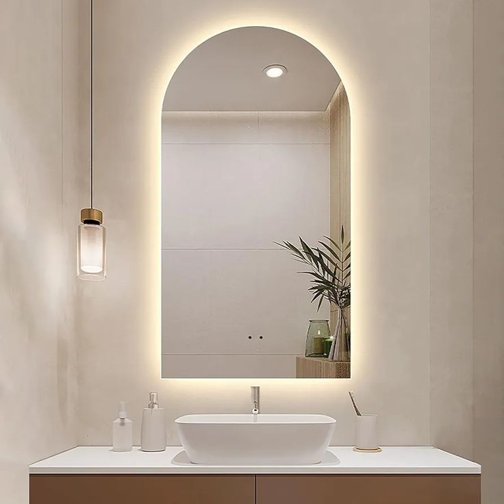 Modern bathroom vanity with illuminated mirror and decorative elements.